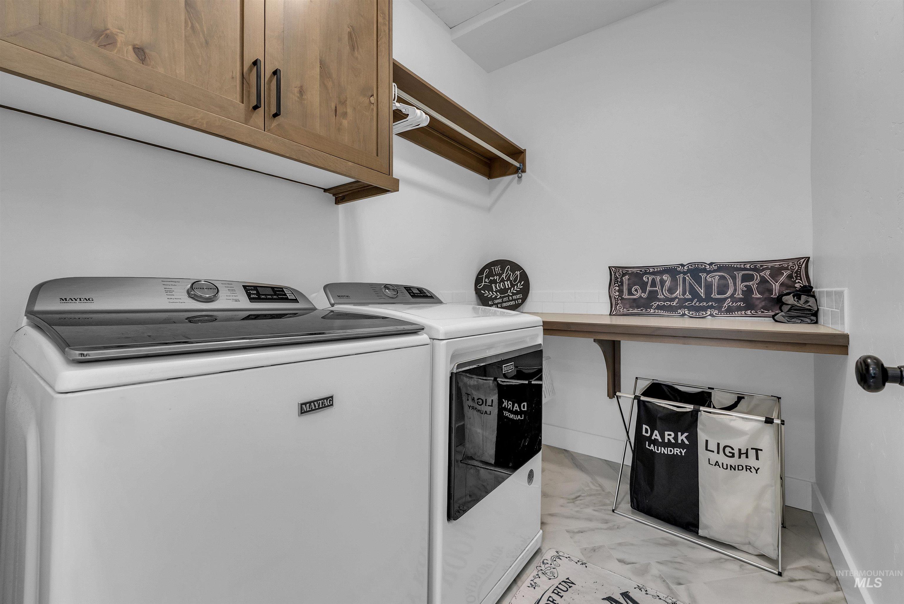 4678 West Riva Capri Street Meridian, ID 83646 - Photo 23 of 30 Washroom featuring light marble finish flooring, cabinet space, and separate washer and dryer
