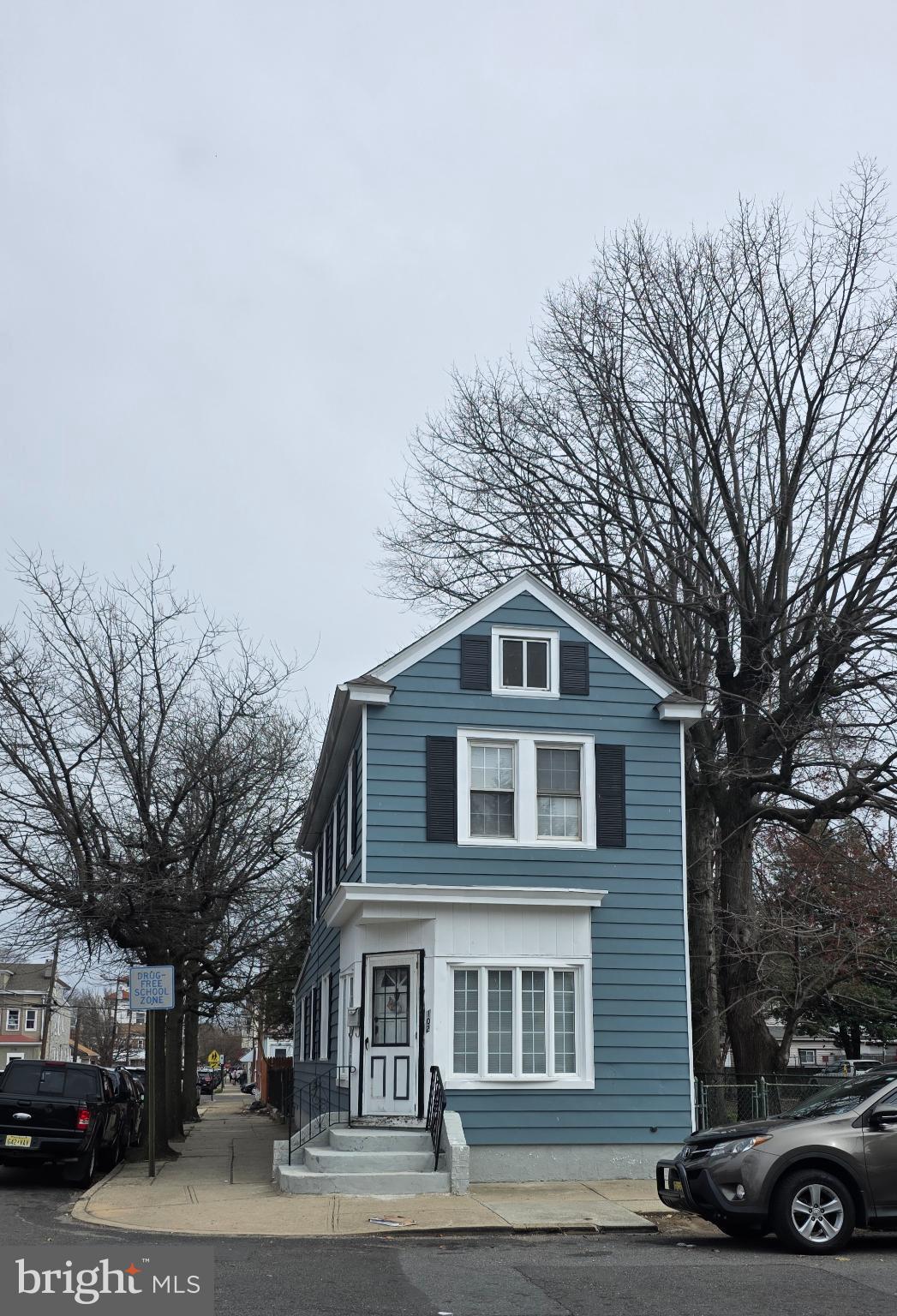 a front view of a building with trees