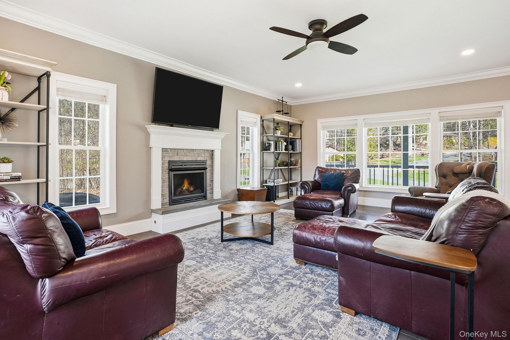 19 Lillian Road Mahopac, NY 10541 - Photo 11 of 50 Living room featuring crown molding, a fireplace, a ceiling fan, wood finished floors, and recessed lighting