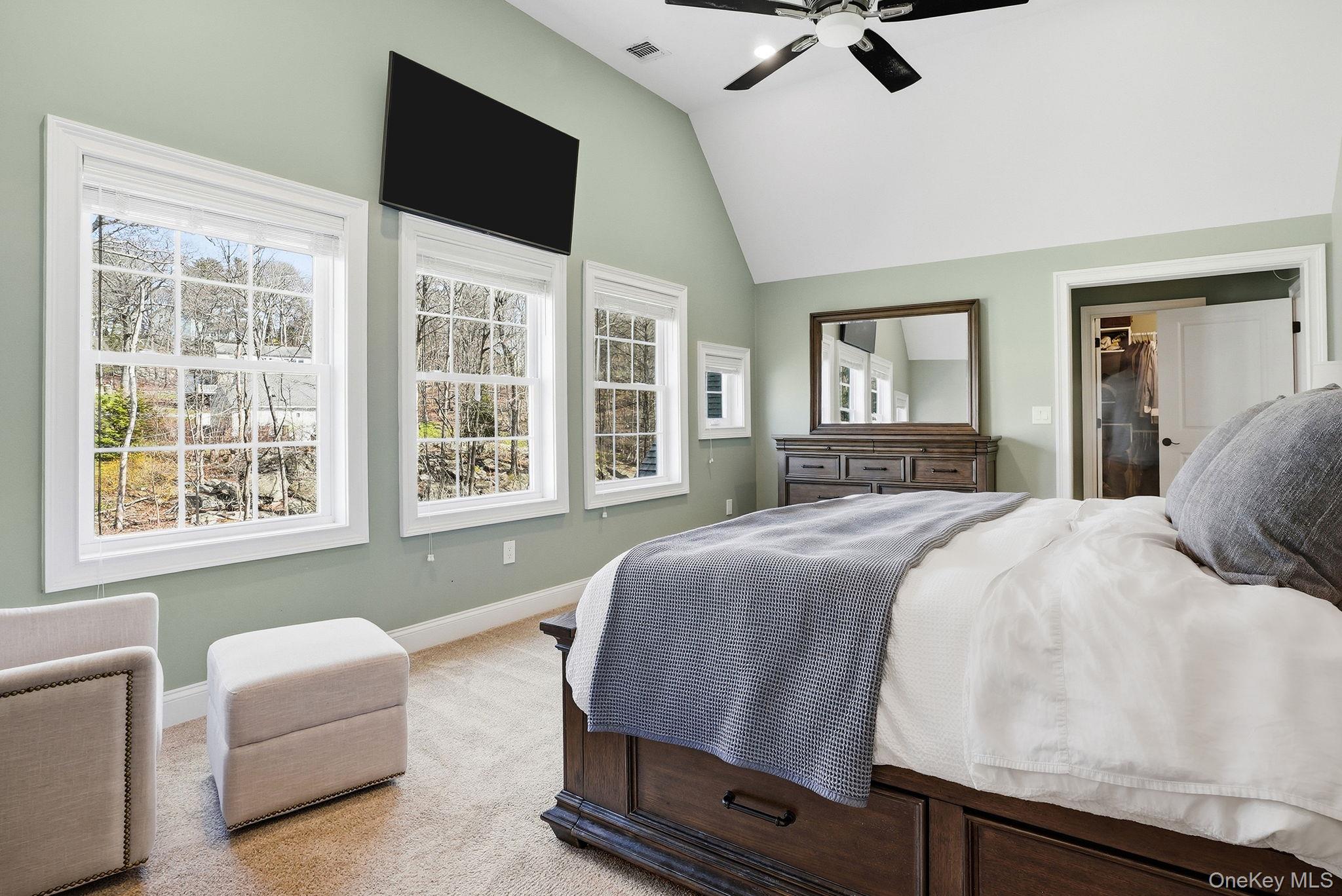 19 Lillian Road Mahopac, NY 10541 - Photo 20 of 50 Bedroom featuring a ceiling fan, multiple windows, light carpet, and vaulted ceiling