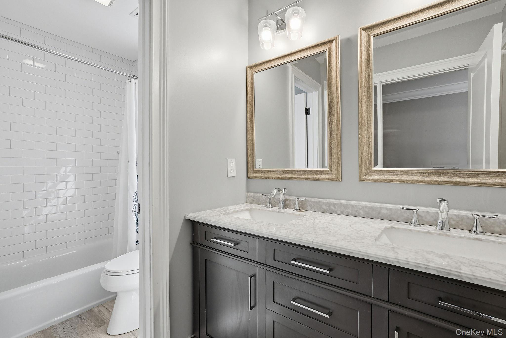 19 Lillian Road Mahopac, NY 10541 - Photo 23 of 50 Full bathroom featuring double vanity, shower / bath combination with curtain, and light wood-style flooring