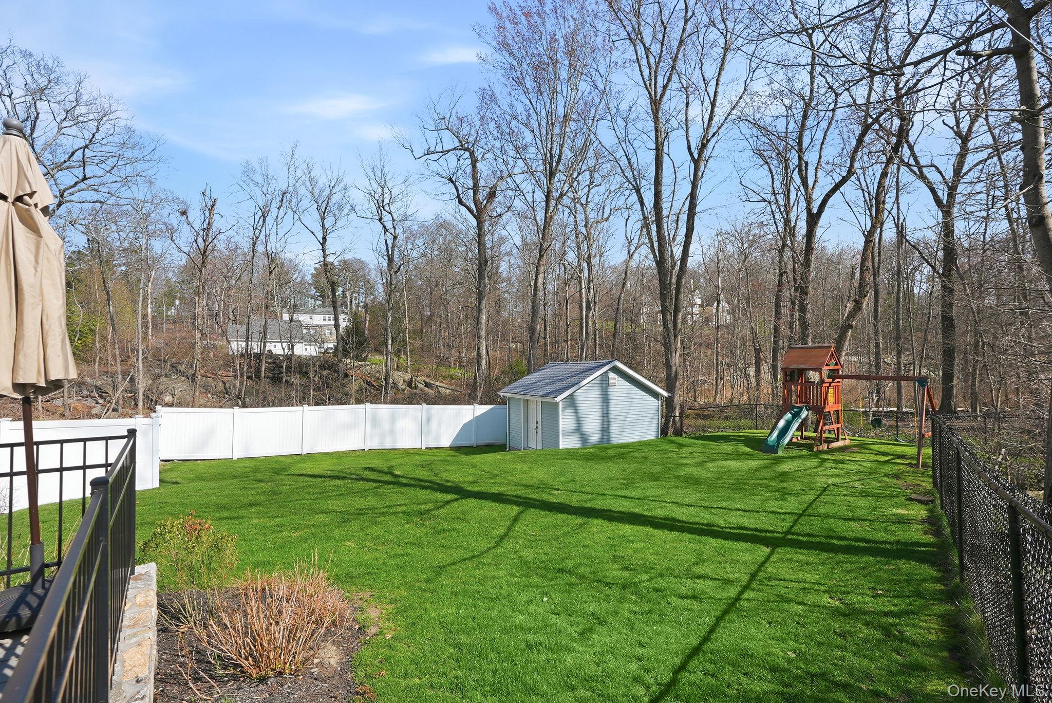 19 Lillian Road Mahopac, NY 10541 - Photo 42 of 50 Fenced backyard with a playground and a storage shed