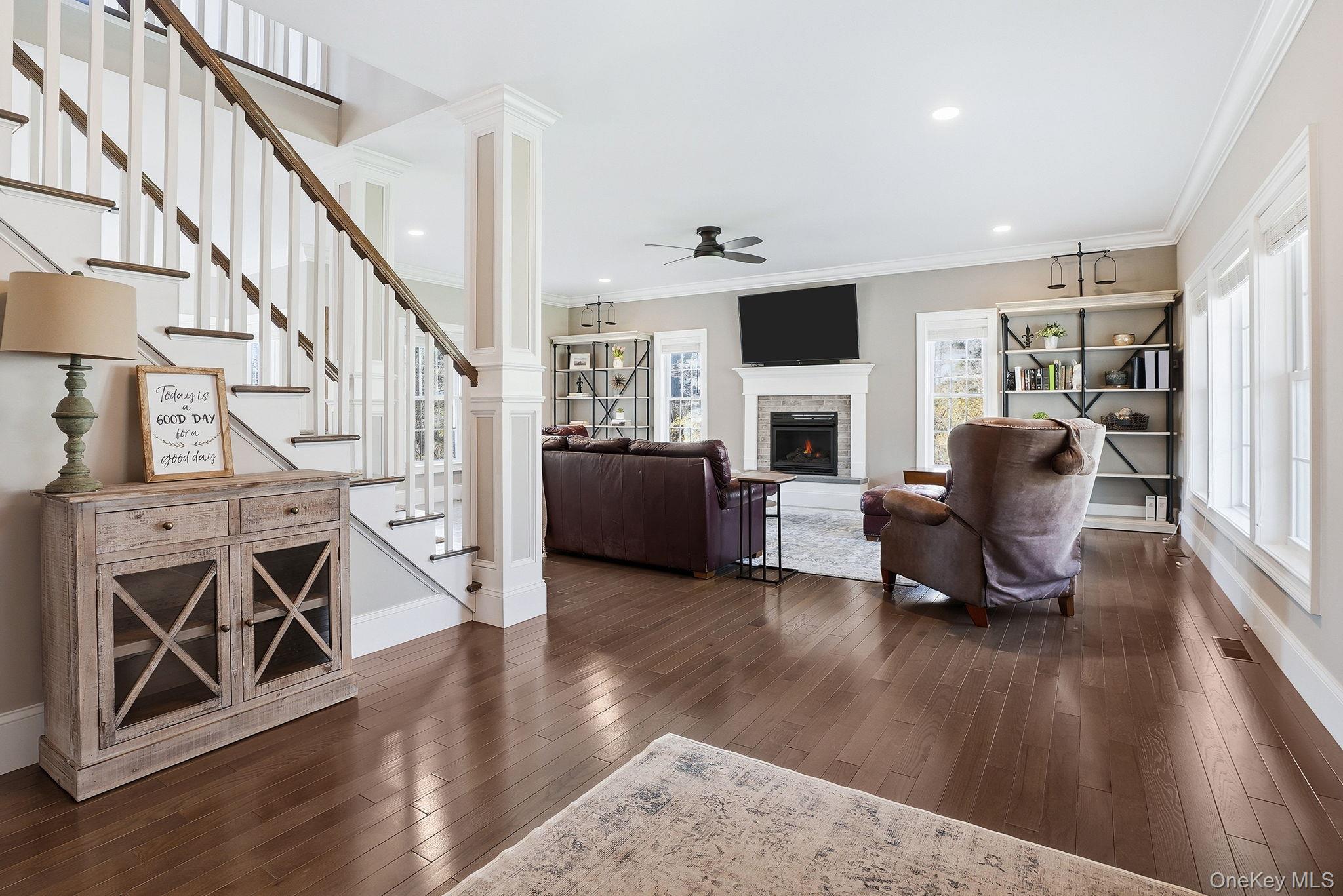 19 Lillian Road Mahopac, NY 10541 - Photo 8 of 50 Living area with crown molding, plenty of natural light, dark wood-style floors, a fireplace, and decorative columns