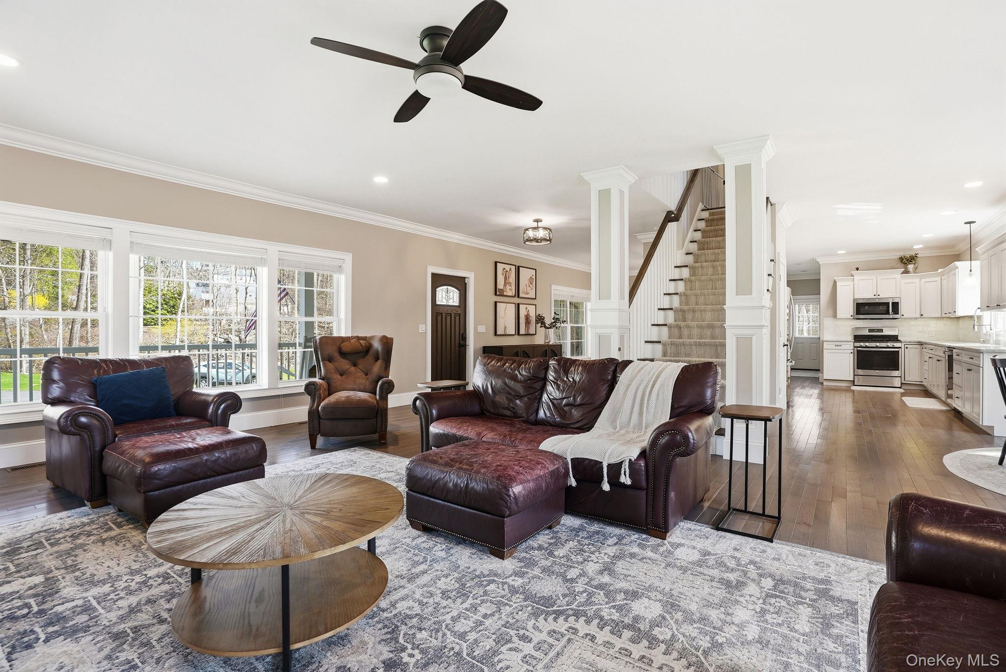 19 Lillian Road Mahopac, NY 10541 - Photo 10 of 50 Living area with decorative columns, ceiling fan, dark wood-type flooring, crown molding, and plenty of natural light