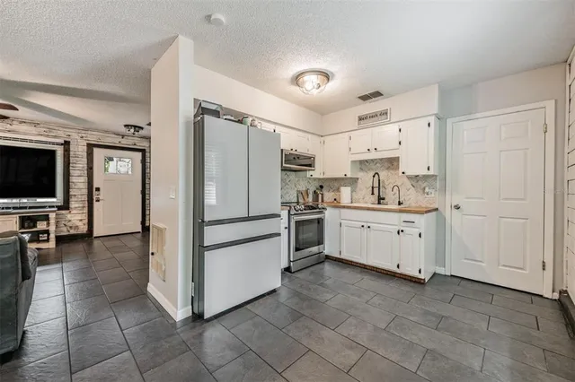 a kitchen with white cabinets and white appliances