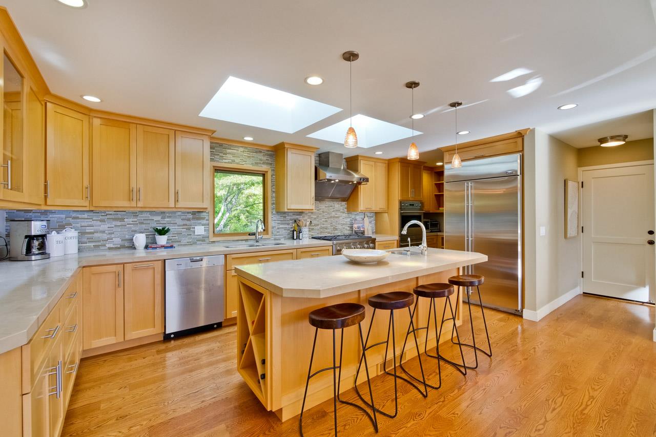 10551 Magdalena Road Los Altos Hills, CA 94024 - Photo 8 of 45 a kitchen with stainless steel appliances granite countertop a table chairs sink and wooden cabinets