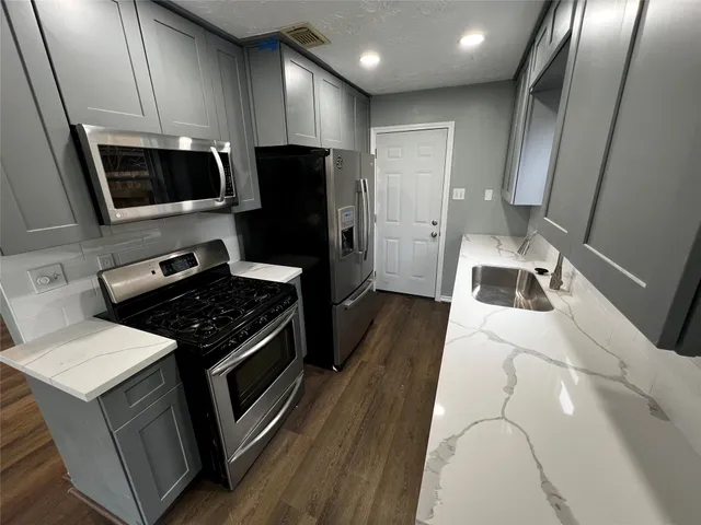 a kitchen with a sink stove and refrigerator