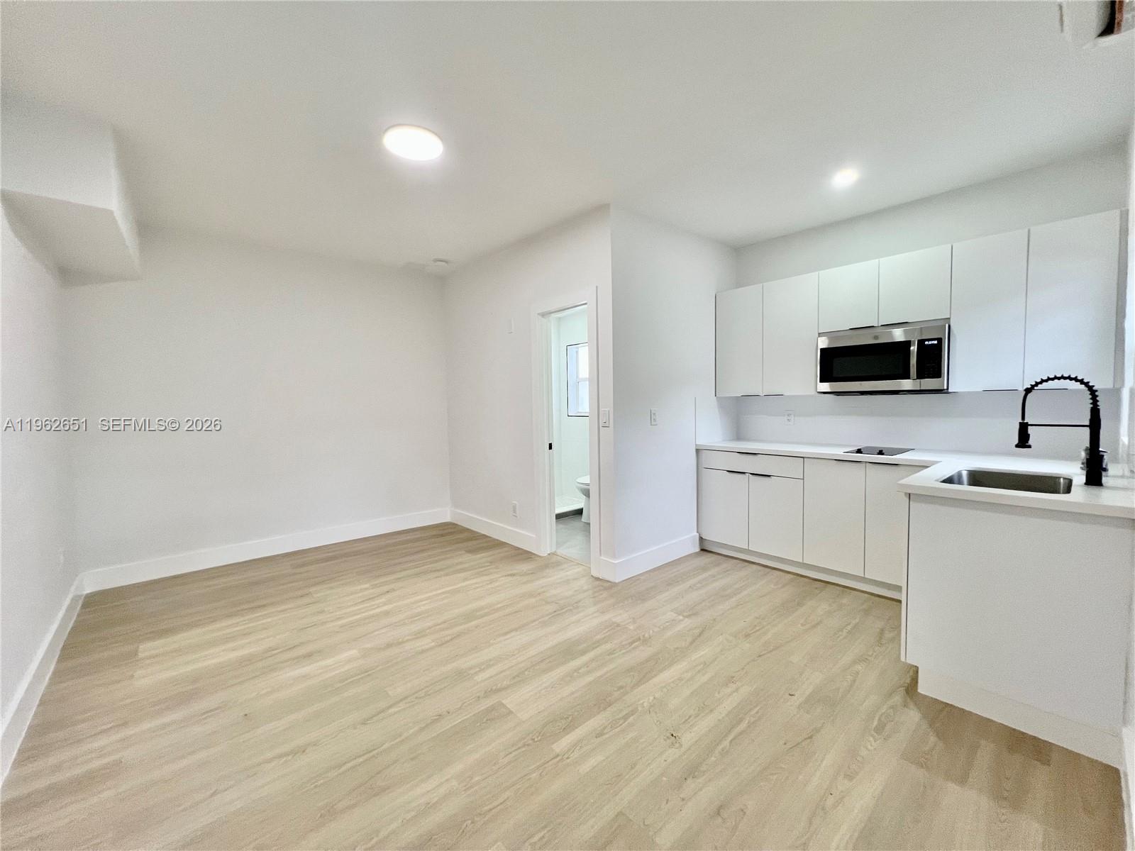 2480 Northwest 96th Street, Unit B Miami, FL 33147 - Photo 1 of 5 a view of a kitchen with white cabinets