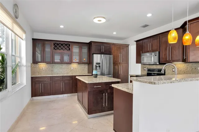 a kitchen with stainless steel appliances granite countertop a sink stove and refrigerator