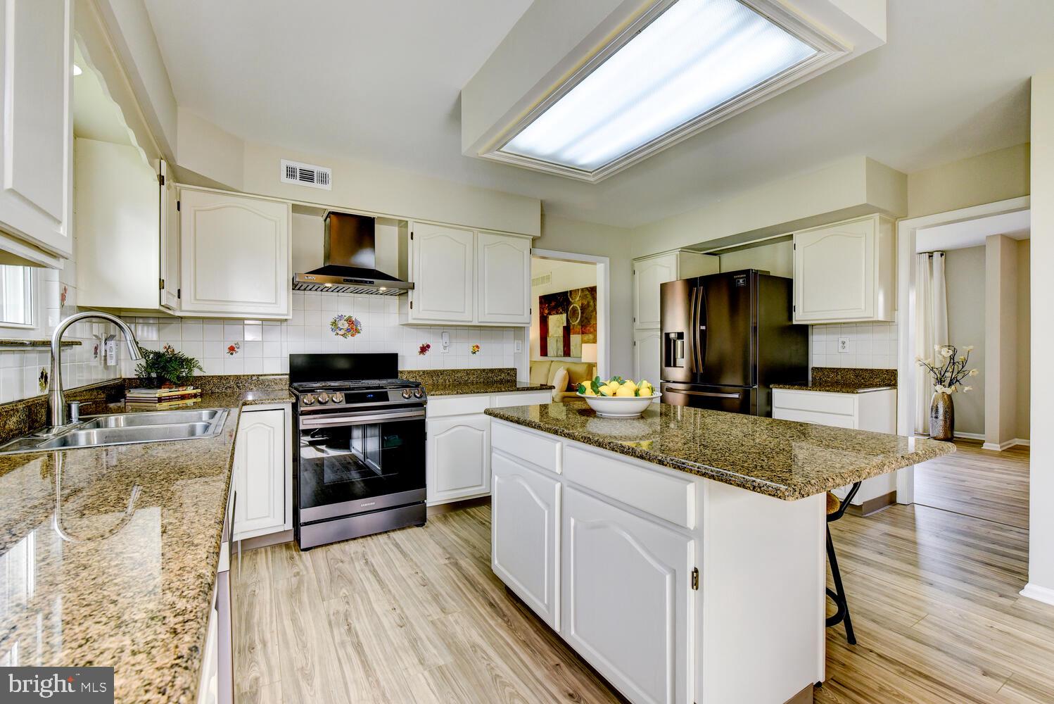 5 Glengarry Way Princeton Junction, NJ 08550 - Photo 25 of 63 a kitchen with stainless steel appliances granite countertop a stove top oven a sink dishwasher a refrigerator and white cabinets with wooden floor