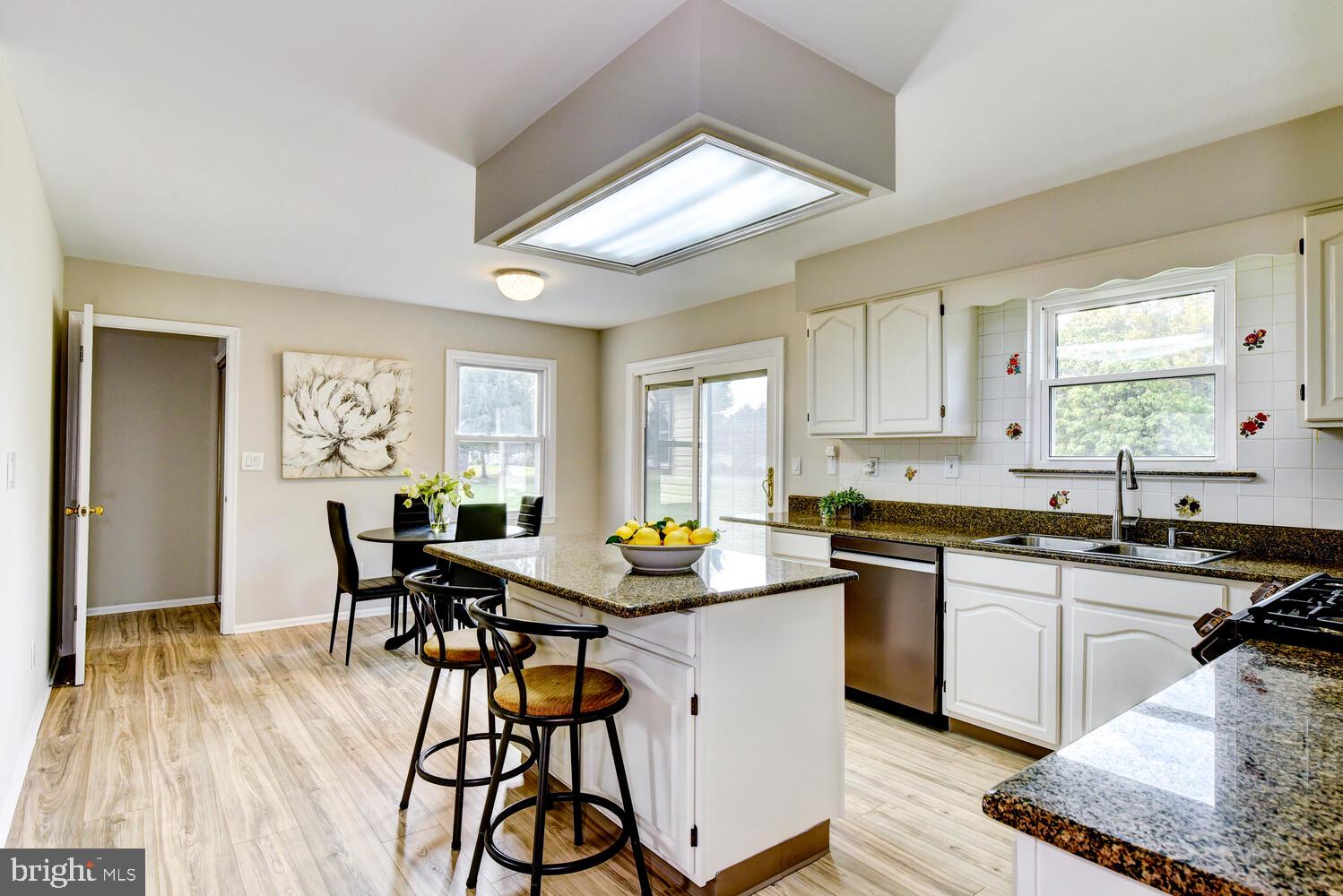 5 Glengarry Way Princeton Junction, NJ 08550 - Photo 26 of 63 a kitchen with stainless steel appliances granite countertop wooden floor dining table and chairs