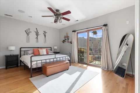 a spacious bedroom with a bed a couch and a large window