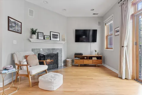 a living room with furniture a flat screen tv and a fireplace