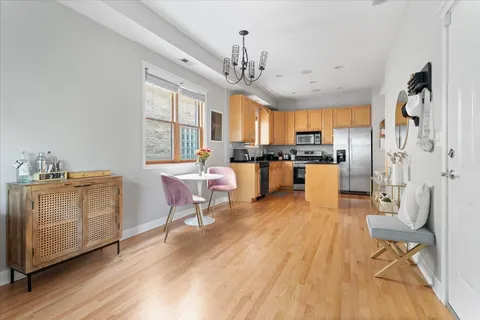 a kitchen with stainless steel appliances granite countertop a stove refrigerator dining table and chairs