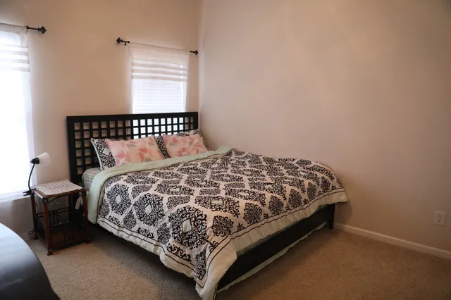 a bed sitting in a bedroom next to a window