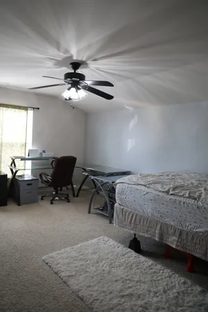 a bedroom with bed and a chandelier