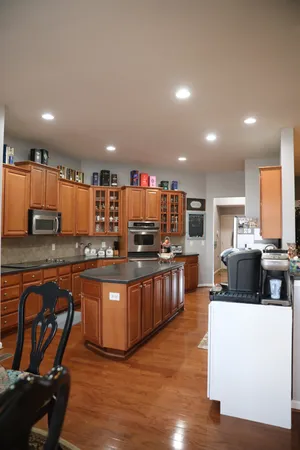 a kitchen with stainless steel appliances kitchen island granite countertop a stove a sink a refrigerator and a refrigerator
