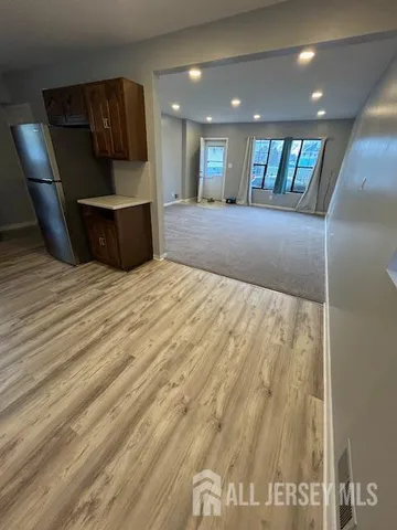 a view of a living room a wooden floor and kitchen view