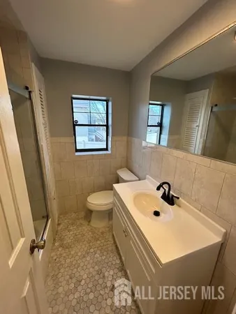 a bathroom with a sink a toilet and mirror