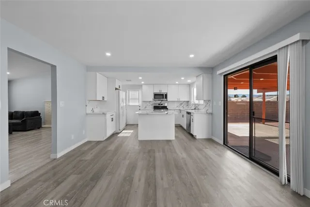a view of a kitchen with wooden floor and electronic appliances