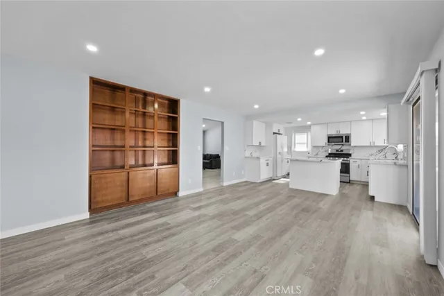 a view of a kitchen with wooden floor and windows