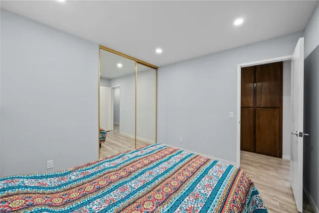 a bedroom with a bed and a wooden floor