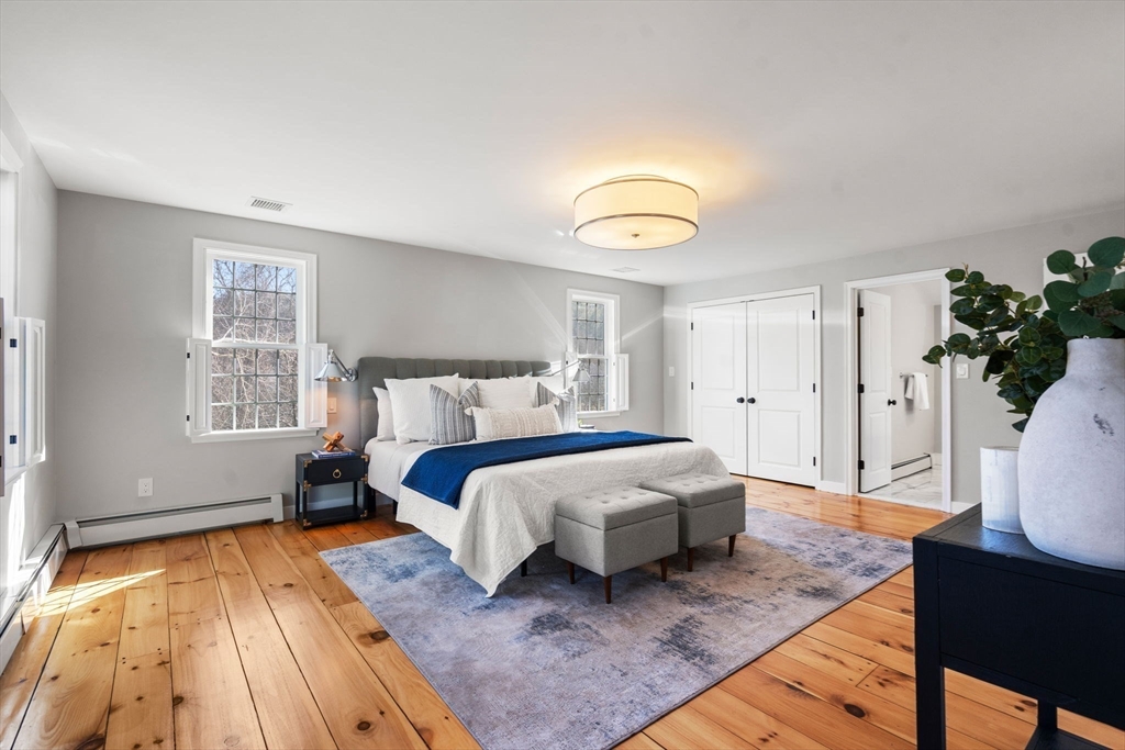 25 Charles Street Hingham, MA 02043 - Photo 11 of 32 a spacious bedroom with a bed a dresser and wooden floor