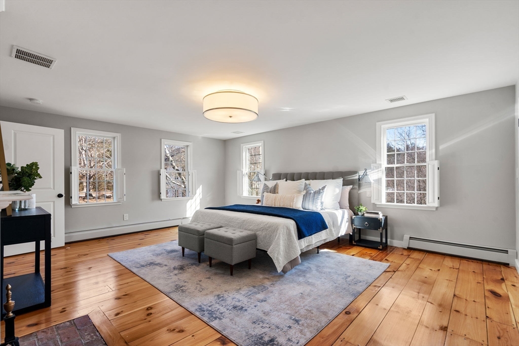 25 Charles Street Hingham, MA 02043 - Photo 12 of 32 a spacious bedroom with a bed couch and a window