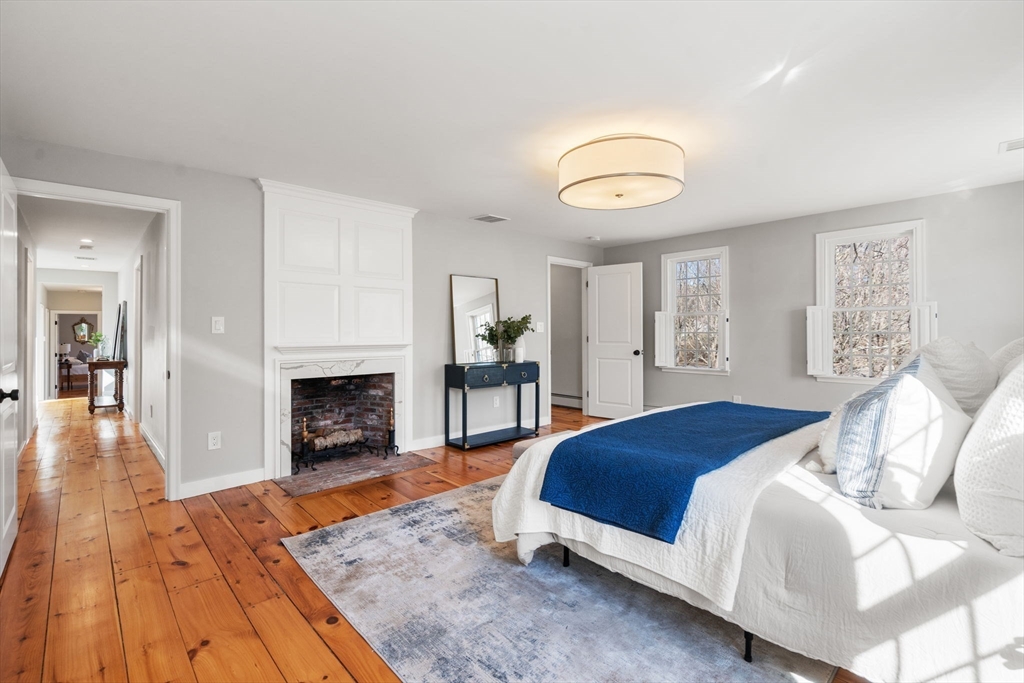 25 Charles Street Hingham, MA 02043 - Photo 13 of 32 a spacious bedroom with a bed and a fireplace