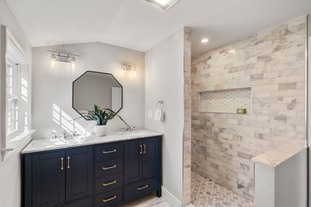 25 Charles Street Hingham, MA 02043 - Photo 15 of 32 a bathroom with a granite countertop sink a mirror and shower
