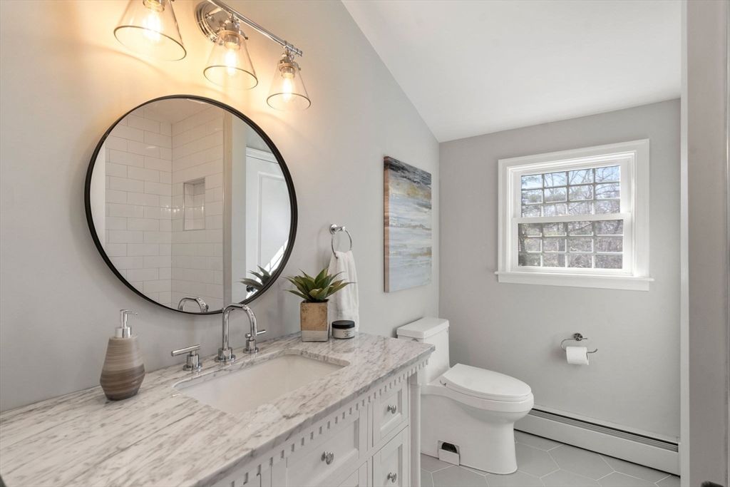 25 Charles Street Hingham, MA 02043 - Photo 18 of 32 a bathroom with a granite countertop toilet a sink and a mirror