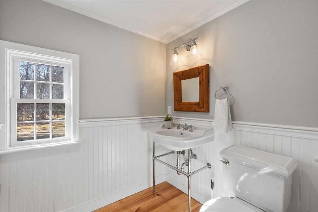 25 Charles Street Hingham, MA 02043 - Photo 10 of 32 a bathroom with a sink a toilet and mirror