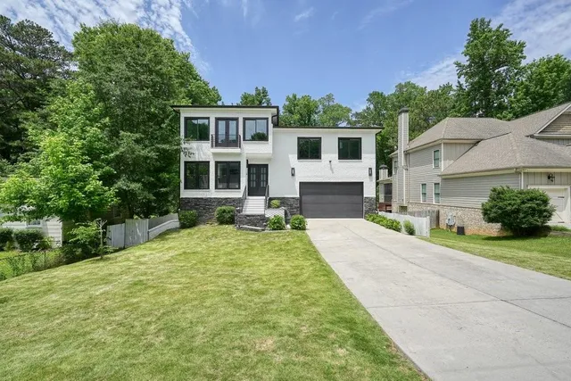 a front view of a house with a yard and potted plants
