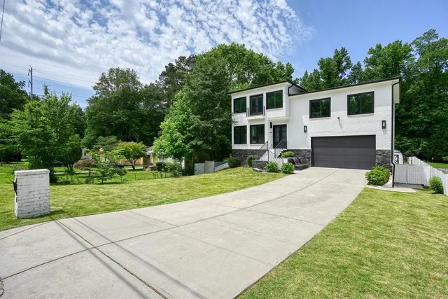 a front view of a house with a yard and trees