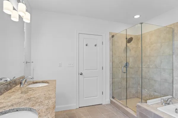 a bathroom with a granite countertop sink a mirror and shower