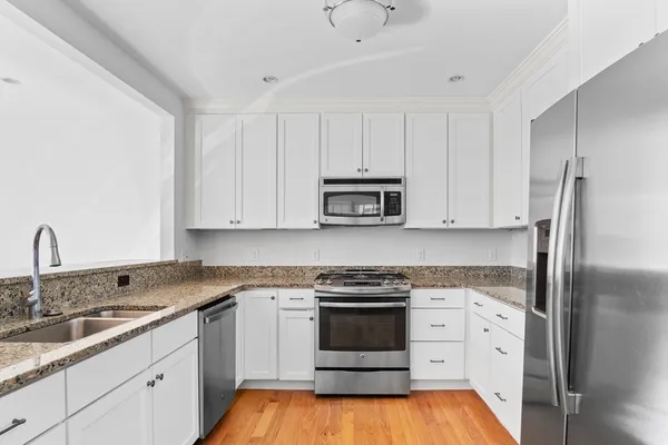 a kitchen with white cabinets and white appliances