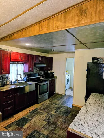 a kitchen with stainless steel appliances kitchen island granite countertop a refrigerator stove and sink