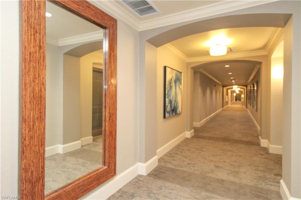 9123 Strada Place, Unit 7410 Naples, FL 34108 - Photo 21 of 50 Corridor with ornamental molding and carpet floors