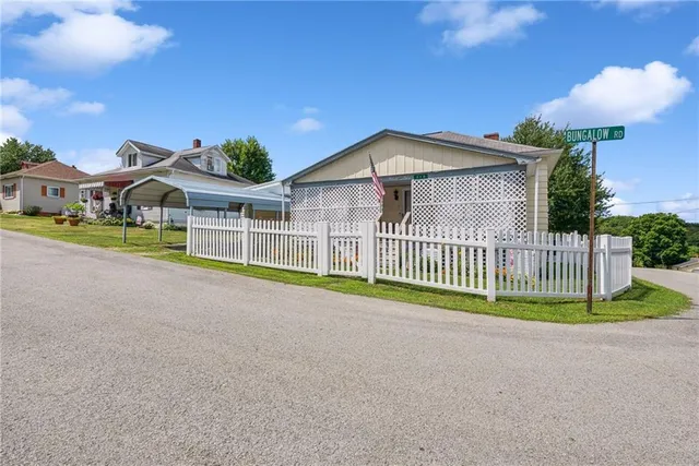 a view of a house with a yard and potted plants