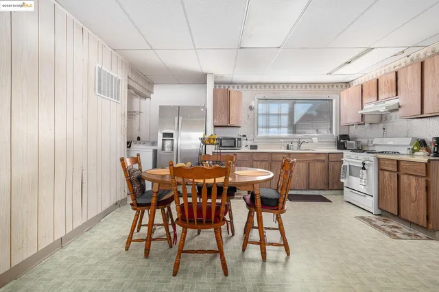 a kitchen with a table chairs sink and cabinets