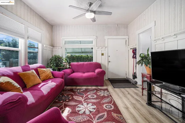 a living room with furniture a flat screen tv and a window