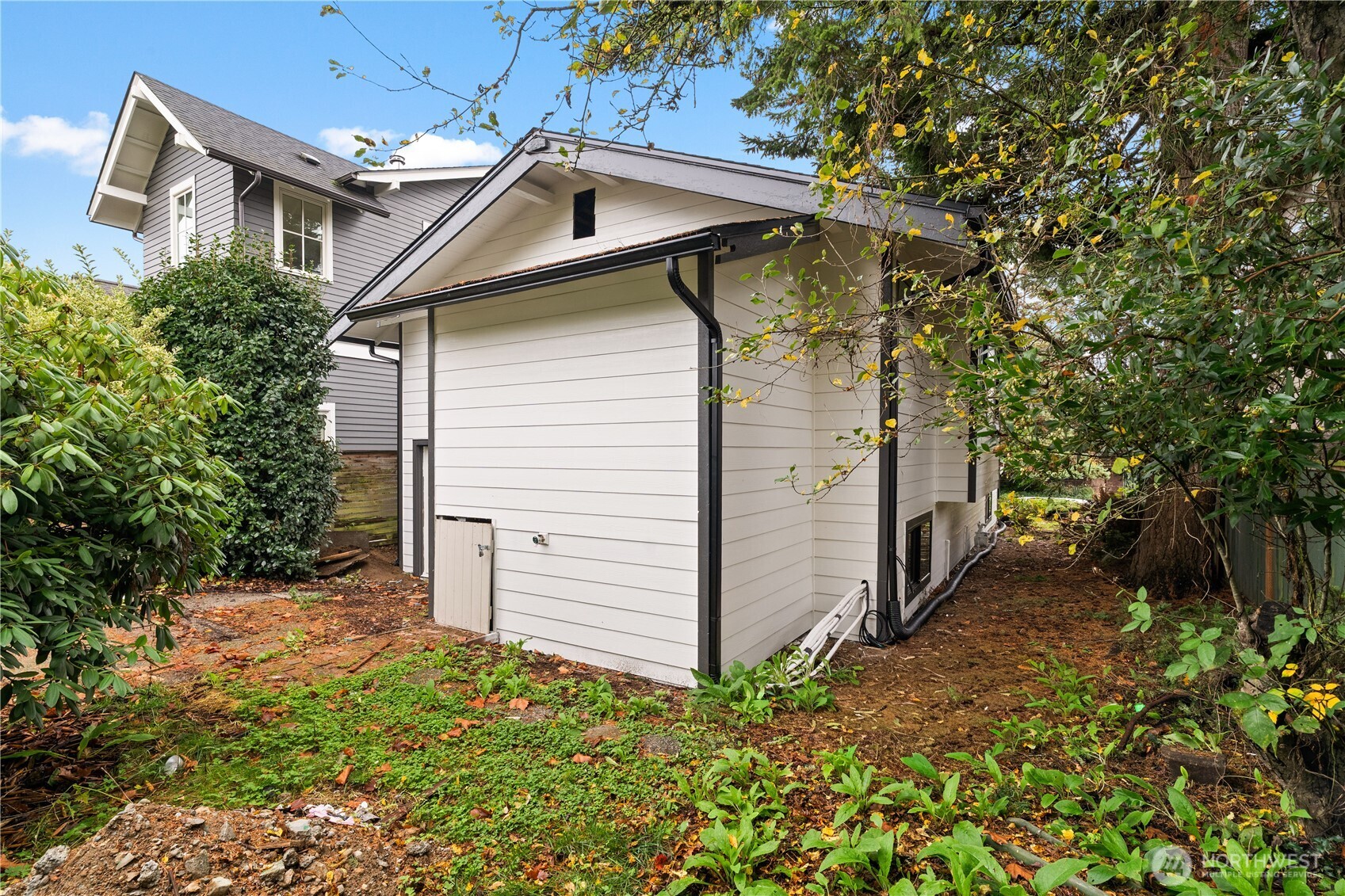 2212 North 46th Street Seattle, WA 98103 - Photo 22 of 25 a view of a white house next to a yard