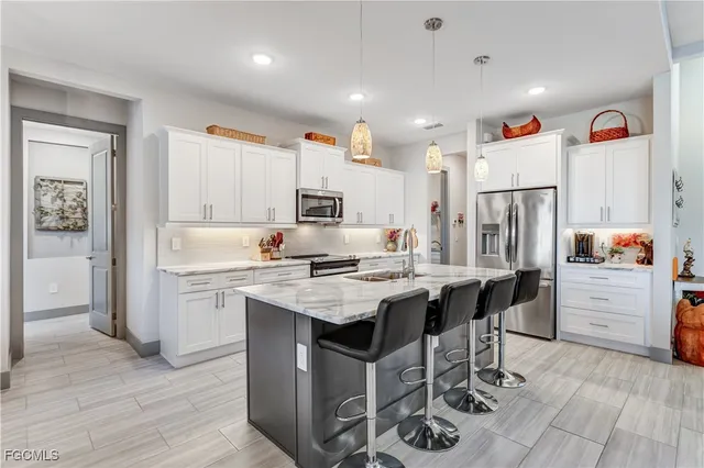 a kitchen with white cabinets and stainless steel appliances