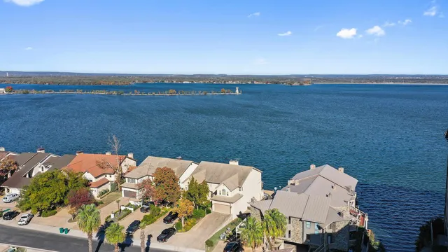 an aerial view of a house with a yard and lake view