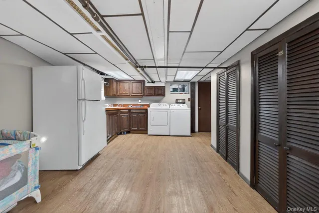 a view of a kitchen with a sink refrigerator and wooden floor