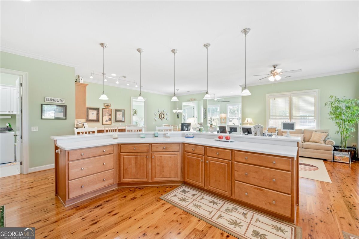 4787 Sunbury Road Midway, GA 31320 - Photo 21 of 72 a large kitchen with kitchen island granite countertop lots of white cabinets