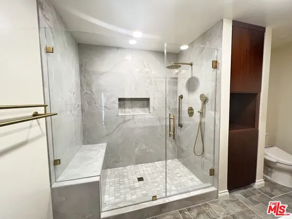 a bathroom with a granite countertop sink toilet and mirror