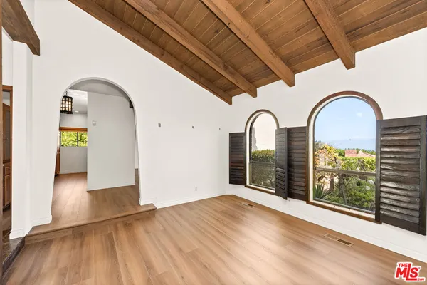 a view of an empty room with a fireplace and a window