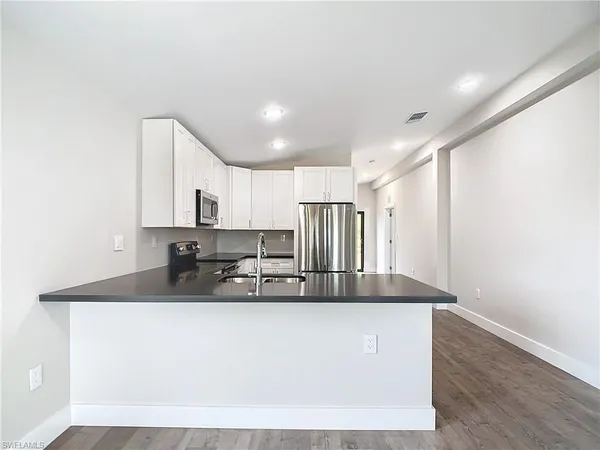 a kitchen with kitchen island a sink and a refrigerator