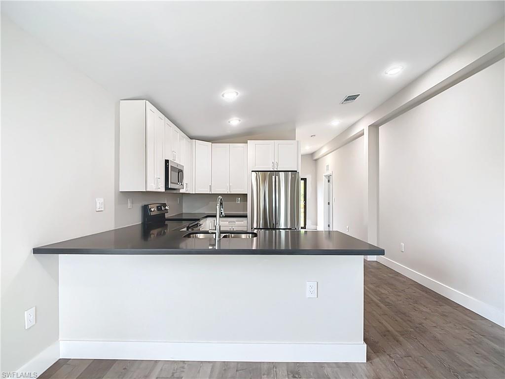 2505 Storter Avenue Naples, FL 34112 - Photo 12 of 49 a kitchen with kitchen island a sink and a refrigerator